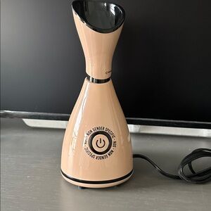 Cream colored Pro facial steaming system with measuring cup and infusion drops